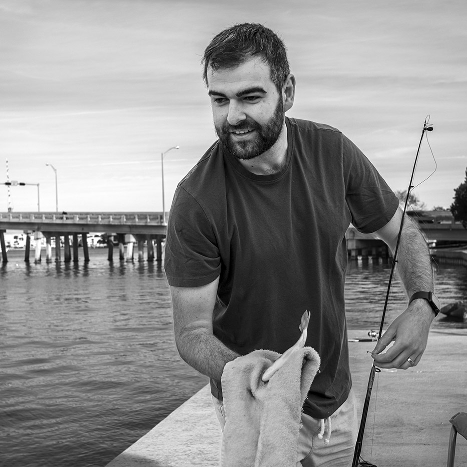 Matthew, an Australian visiting family on holiday in St. Pete Beach, prepares to return a small pinfish that he caught while fishing at the Michael Horan Park overlooking the Corey Causeway on New Year’s Day, 2024.